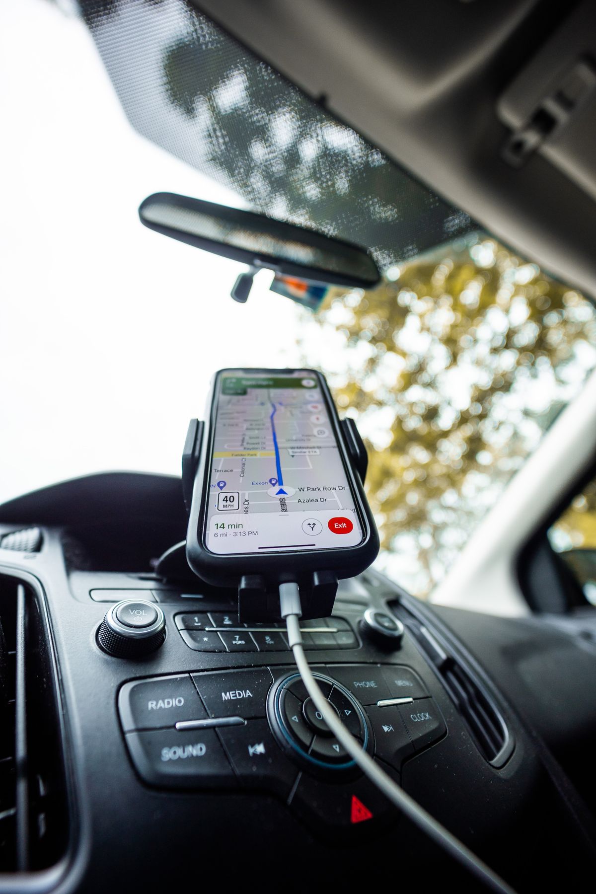 A charging cable connected to a phone mounted for navigation inside a car